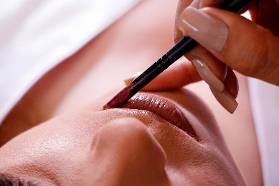 Close-up of a lip pencil creating a defined lip line on a model with flawless makeup