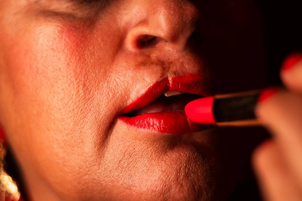 Makeup artist demonstrating double lip contour pencil technique with two shades for 3D effect